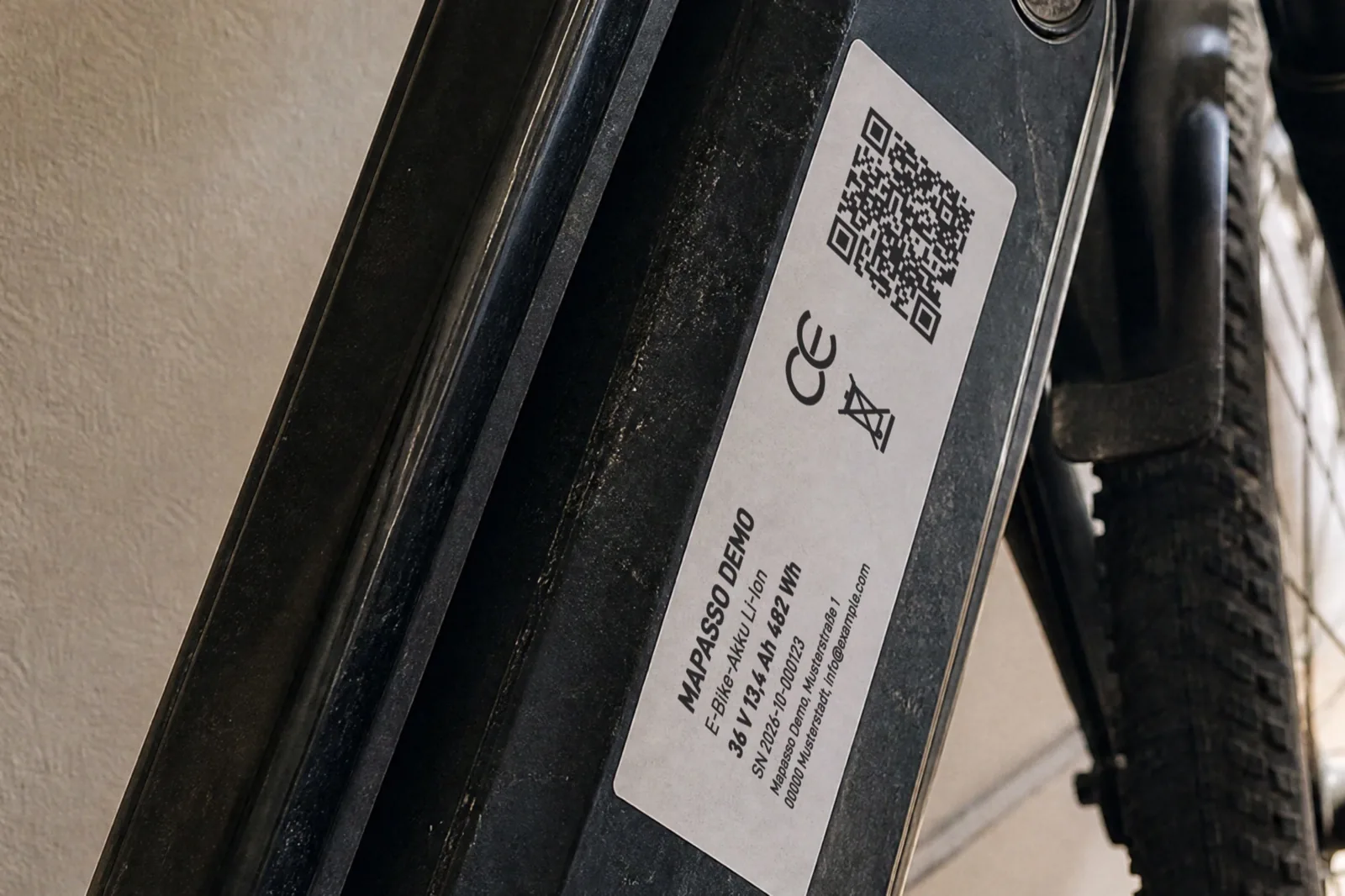 KI-generiertes Bild: Typenschild am Akku eines E-Bikes mit QR-Code, „Mapasso Demo“, Li-Ion, 36 V, 13,4 Ah, 482 Wh, Seriennummer, CE-Zeichen und durchgestrichener Mülltonne